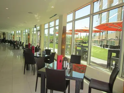 a dining room with tables and chairs and windows at University Plaza Waterfront Hotel in Stockton