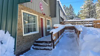 a fence covered in snow next to a building at Cinnamon Bear Inn in Mammoth Lakes