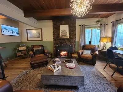 a living room with a fireplace and a table at Cinnamon Bear Inn in Mammoth Lakes