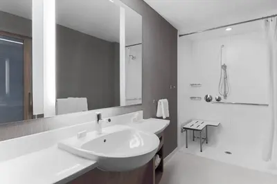 a white bathroom with a sink and a shower at Hotel Vista Sierra in Auburn