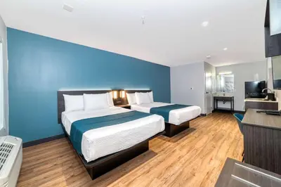 a hotel room with two beds and a blue wall at Studio 6 Suites Stockton, CA Waterfront in Stockton