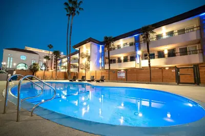 a swimming pool in front of a building at night at Studio 6 Suites Stockton, CA Waterfront in Stockton