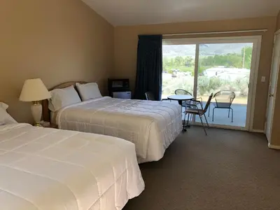 a hotel room with two beds and a balcony at Meadowcliff Lodge Coleville in Coleville