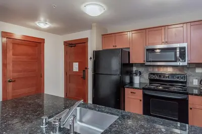 a kitchen with a black refrigerator and a sink at Village 3211 in Mammoth Lakes