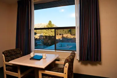 a table and chairs in a room with a large window at Shilo Inn Mammoth Lakes in Mammoth Lakes