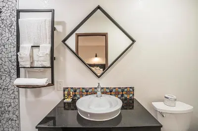 a bathroom with a sink and a mirror at The Greens Hotel on Stockton in Sacramento