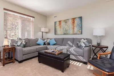 a living room with a gray couch and blue pillows at Silver Bear #19 Condo in Mammoth Lakes