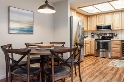 a kitchen with a table and chairs and a refrigerator at Silver Bear #19 Condo in Mammoth Lakes