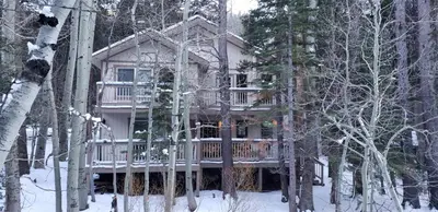 a large house with a deck in the woods at Birch Creek #8 - 2BR/1.5BA in June Lake