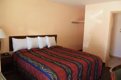 a hotel room with a large bed with white pillows at Gold Trail Motor Lodge in Placerville
