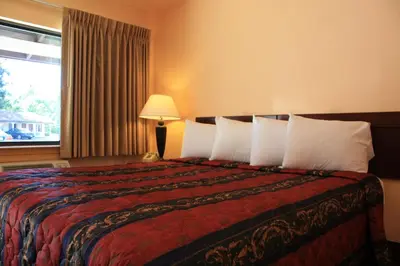 a hotel room with a bed with pillows and a window at Gold Trail Motor Lodge in Placerville