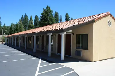 a building with columns and a red roof at Gold Trail Motor Lodge in Placerville