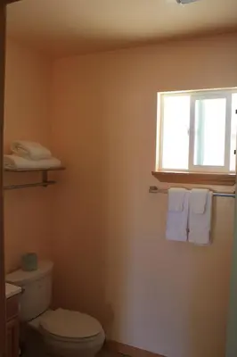 a bathroom with a toilet and a window and towels at Gold Trail Motor Lodge in Placerville