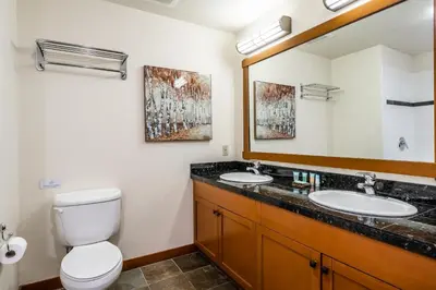a bathroom with two sinks and a toilet and a mirror at Village # 3310 - Lincoln House in Mammoth Lakes
