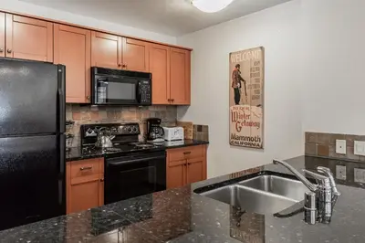 a kitchen with a black refrigerator and a sink at Village # 3310 - Lincoln House in Mammoth Lakes