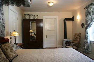 a bedroom with a bed and a mirror at Eureka Street Inn in Sutter Creek