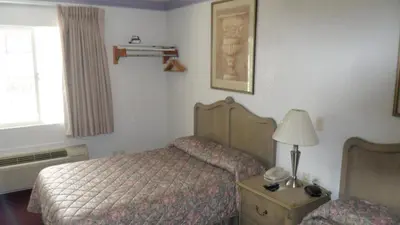 a bedroom with a bed and a lamp on a table at Budget Inn of Lodi in Lodi