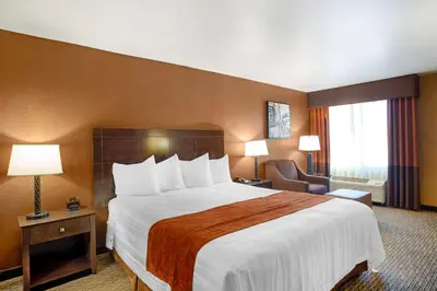 a hotel room with a large bed and a chair at Best Western Exeter Inn & Suites in Exeter
