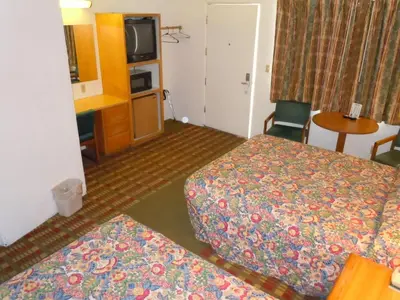 a hotel room with two beds and a tv at Value Inn in Fallon