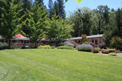 a yard with a house in the background at Mother Lode Motel in Placerville