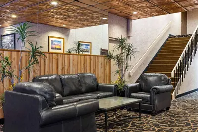 a waiting room with leather couches and a staircase at Super 8 by Wyndham Fallon in Fallon
