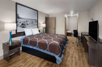 a hotel room with a bed and a flat screen tv at Super 8 by Wyndham Fallon in Fallon