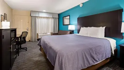 a hotel room with a large bed and a desk at Best Western Apricot Inn in Chaney Ranch
