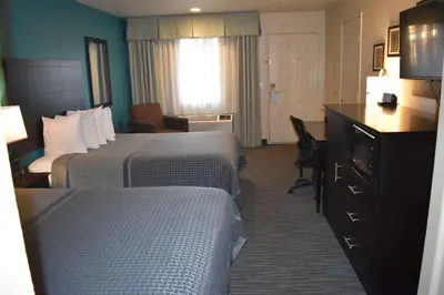 a hotel room with two beds and a desk at Best Western Apricot Inn in Chaney Ranch
