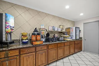 a kitchen with wooden cabinets and a counter top at Days Inn by Wyndham Lost Hills in Lost Hills