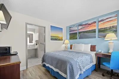 a hotel room with a bed and a desk at Days Inn by Wyndham Lost Hills in Lost Hills