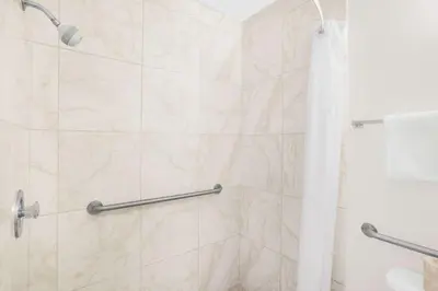 a bathroom with a shower with a marble wall at Days Inn by Wyndham Lost Hills in Lost Hills