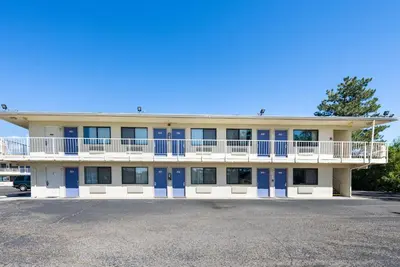an apartment building with blue doors and a parking lot at Motel 6-Carson City, NV in Carson City