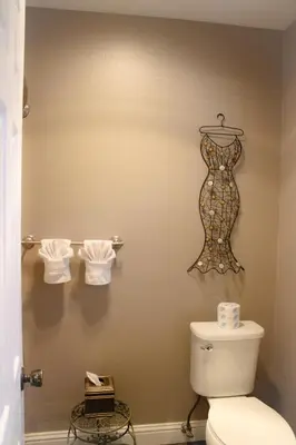 a bathroom with a toilet and a mannequin on the wall at The Alder Inn in South Lake Tahoe