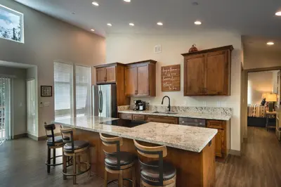 a kitchen with wooden cabinets and a counter with bar stools at 11R Spring Meadow Retreat in Wawona