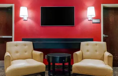 two chairs and a tv on a red wall at Extended Stay America Suites - Sacramento - Elk Grove in Elk Grove