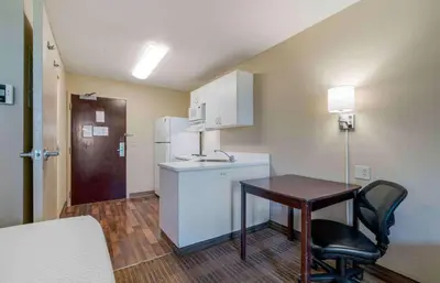 a small kitchen with a table and a refrigerator at Extended Stay America Suites - Sacramento - Elk Grove in Elk Grove