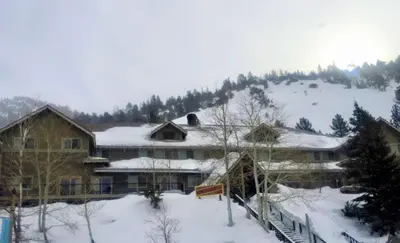 a large house with snow on top of a mountain at Heidelberg Inn & Resort in June Lake