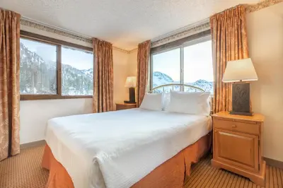 a bedroom with a bed and a large window at Heidelberg Inn & Resort in June Lake