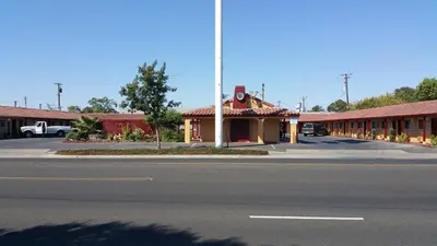 an empty street in front of a building at Slumber Motel in Merced