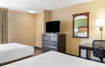a hotel room with two beds and a flat screen tv at Extended Stay America Suites - Stockton - Tracy in Tracy