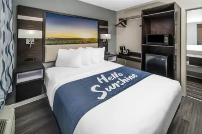 a hotel room with a large bed with a large window at Days Inn by Wyndham Galt - Elk Grove South in Galt
