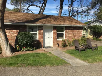 a brick house with two chairs in front of it at Lazy J Ranch Motel in Three Rivers