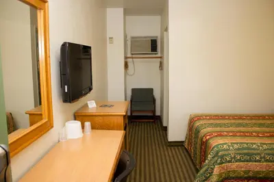 a hotel room with a bed and a television at King's Rest Motel in Gilroy