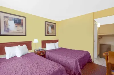 two beds in a hotel room with purple blankets at Baymont by Wyndham Coalinga in Coalinga