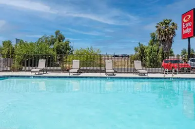 a swimming pool at a hotel with chairs and a sign at Econo Lodge Stockton near I-5 Fairgrounds in Stockton