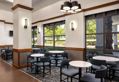 a restaurant with tables and chairs and windows at Hyatt Place Sacramento Rancho Cordova in Rancho Cordova