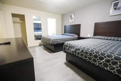 a hotel room with two beds and a desk at Sky Riders Motel in Sacramento