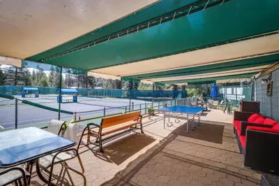 a tennis court with several tables and benches on a tennis court at Inviting, Comfortable Mountain Home in Truckee