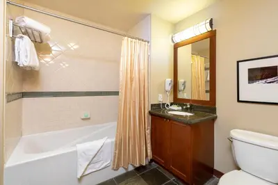 a bathroom with a tub and a toilet and a sink at The Village at Palisades Tahoe in Olympic Valley
