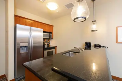 a kitchen with a stainless steel refrigerator and a sink at The Village at Palisades Tahoe in Olympic Valley